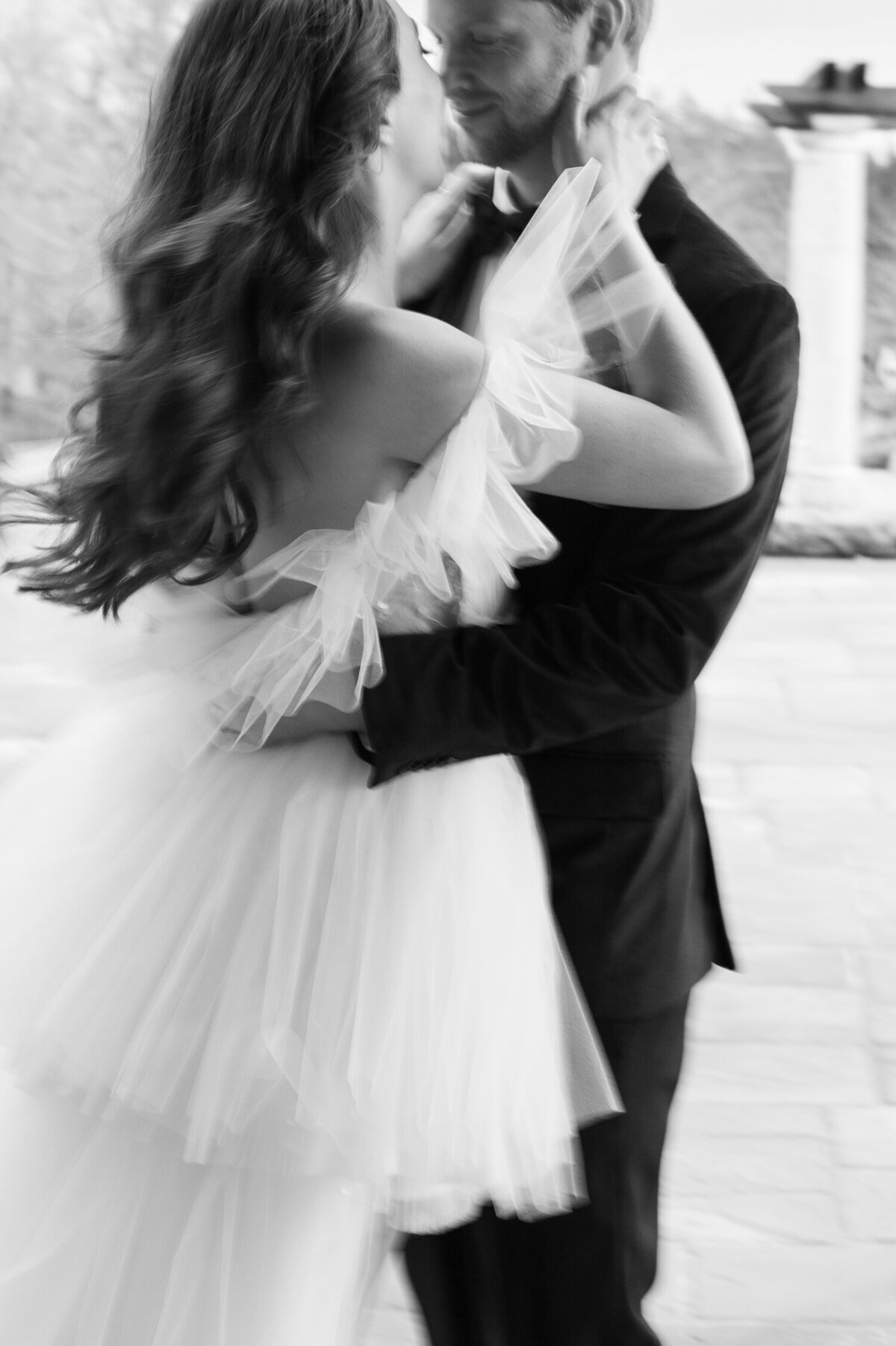 romantic couple dancing shot on black and white film with motion blur 