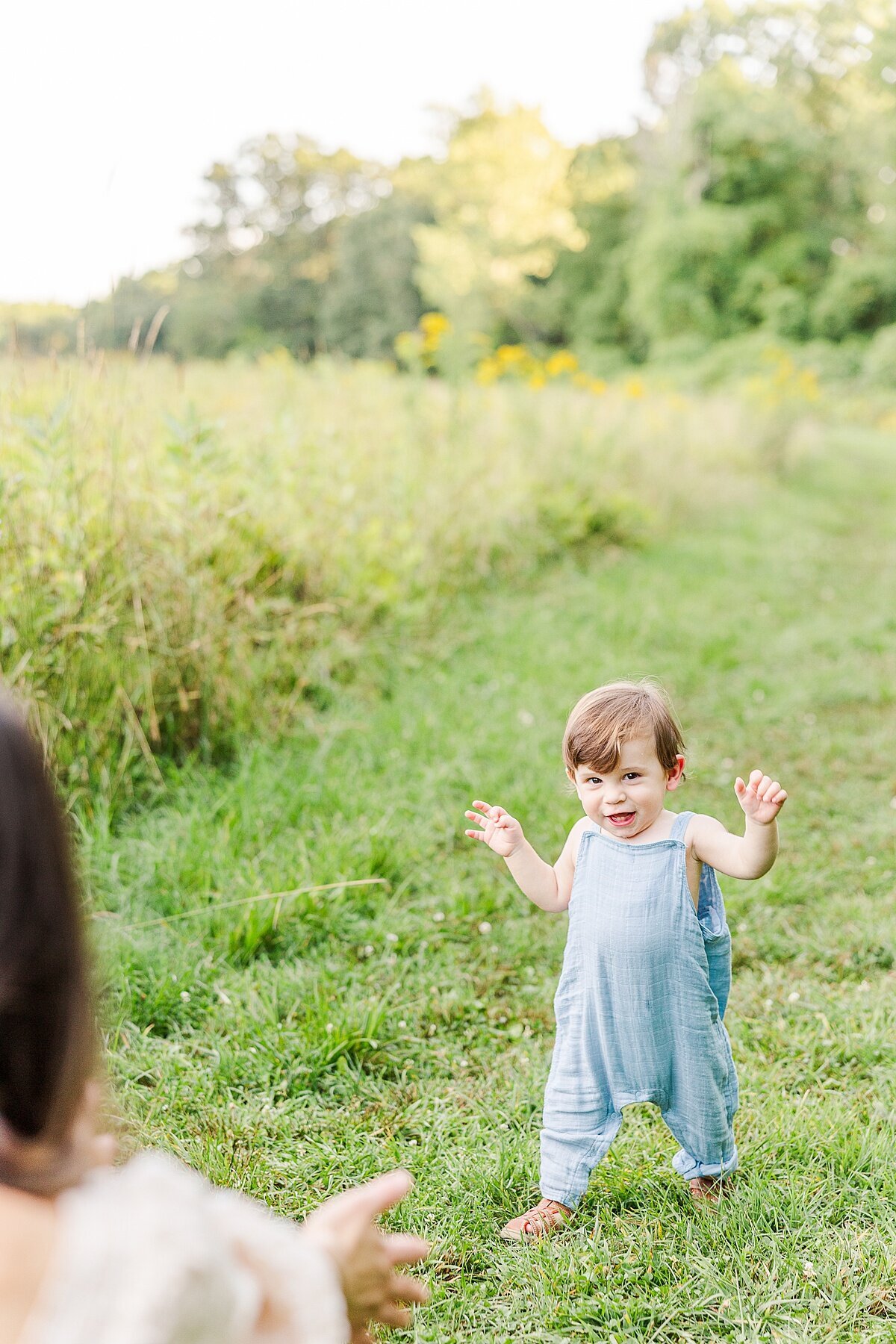 boy walks towards his mother during Family photo session with Sara Sniderman Photography at Heard Farm in Wayland Massachusetts