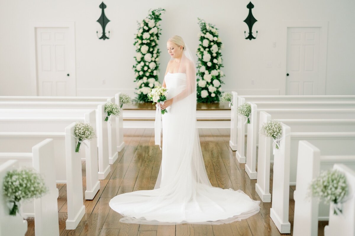 a bride posing in a white chapel