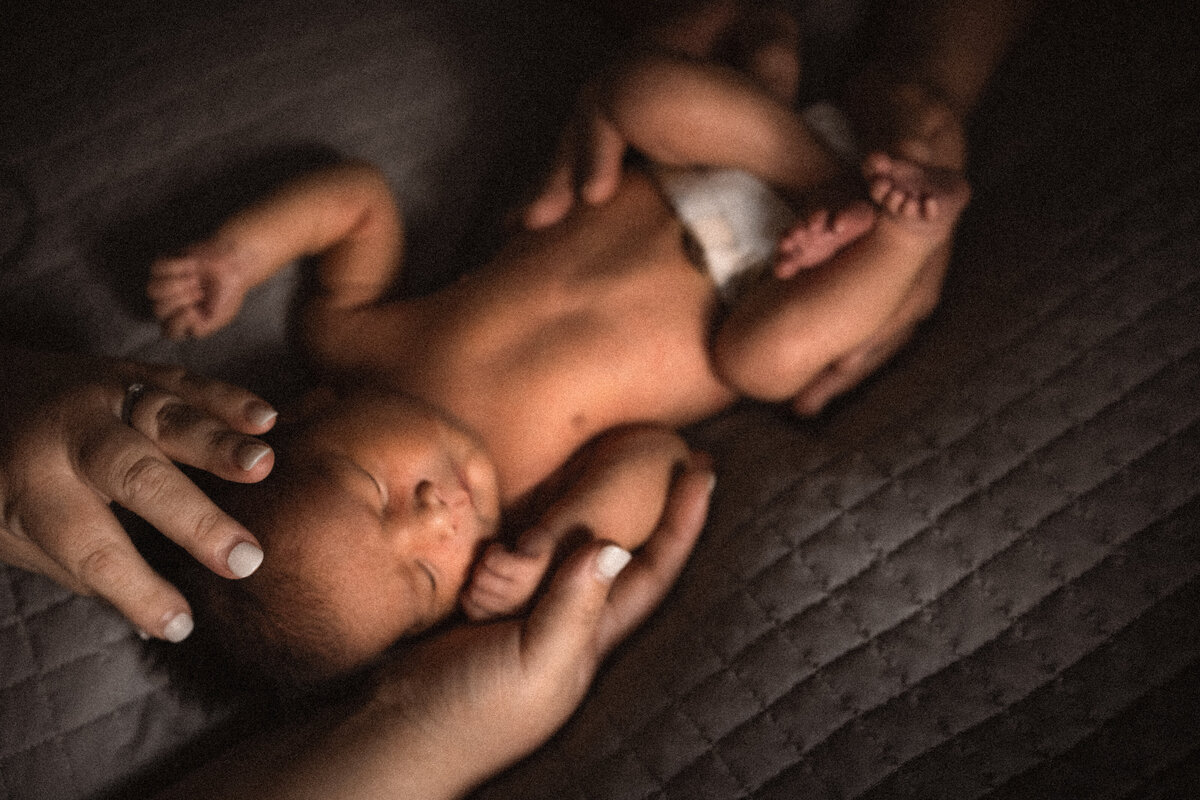 Hands holding newborn baby