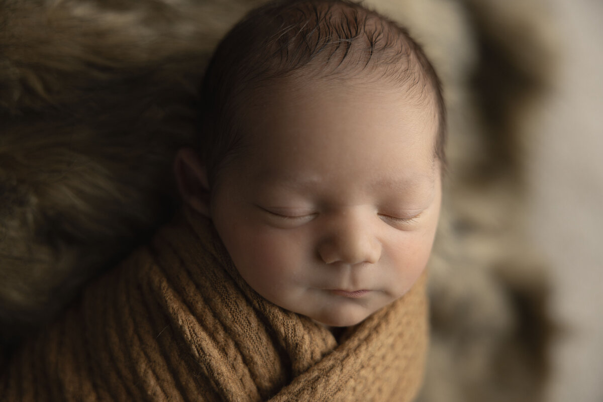 A close up of this newborns face shows off his delicate details, captured by ShutterLee Photography.