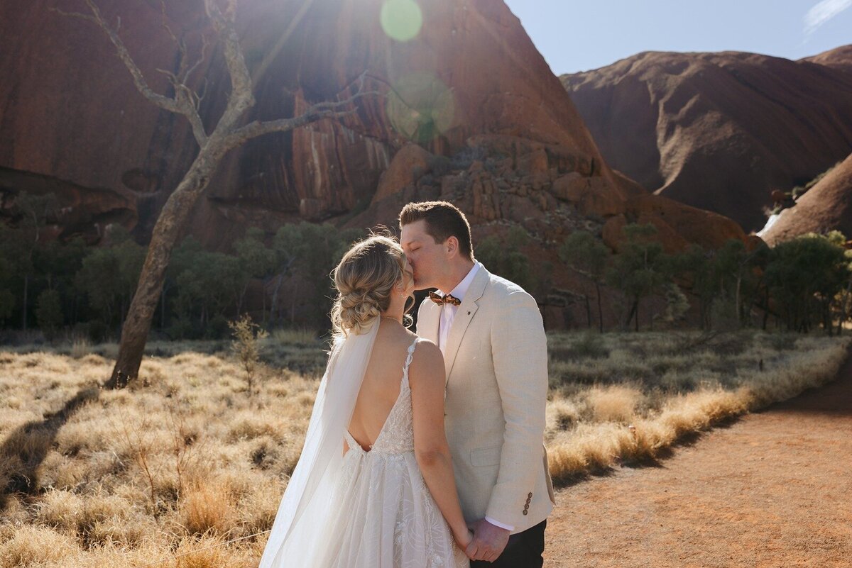 Bride and groom kissing at Uluru