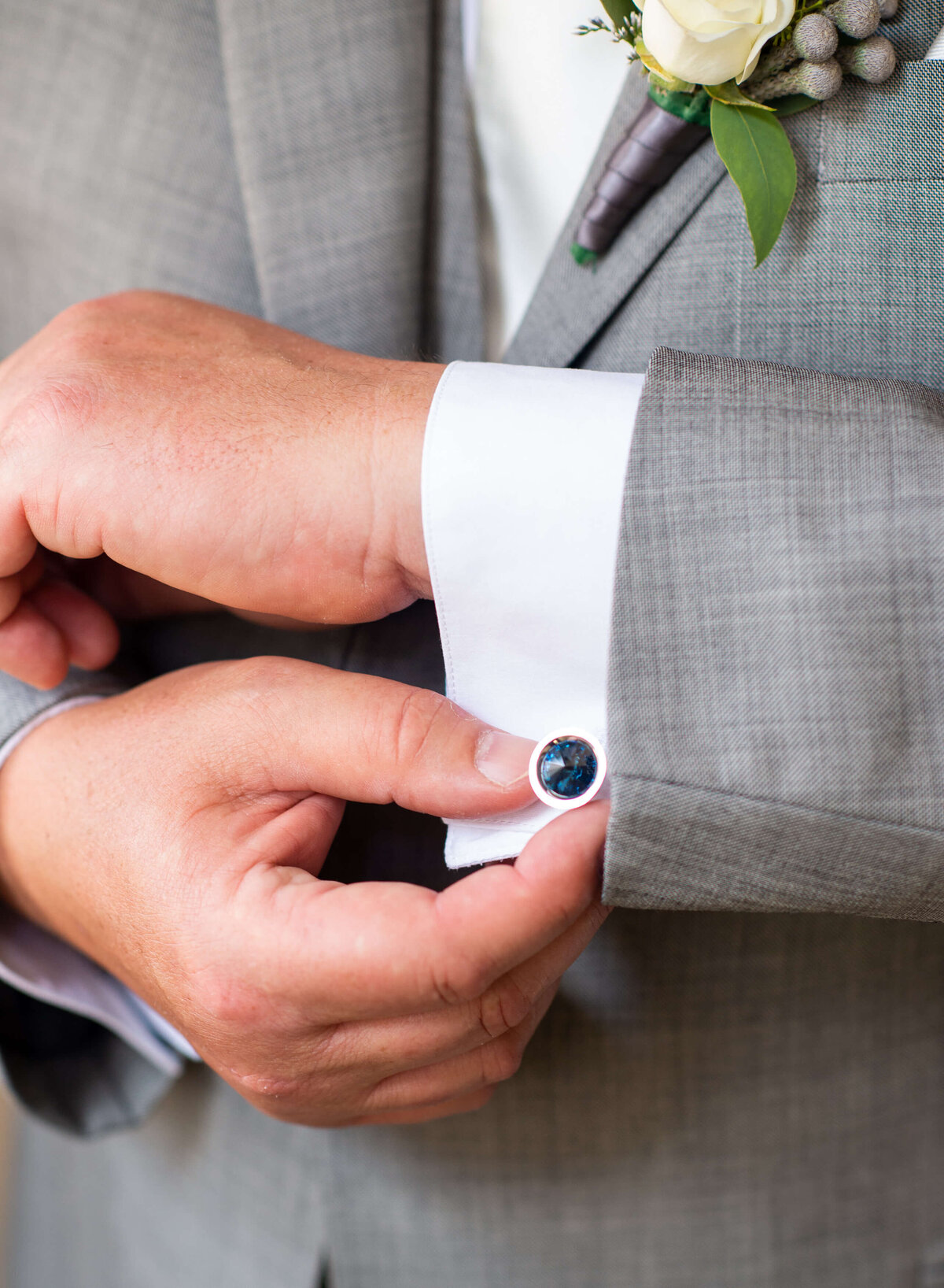 A groom adjusts his cufflinks as he gets dressed for his Ottawa wedding