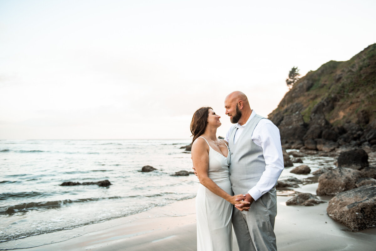 bride and groom look at each other on  Washington coast