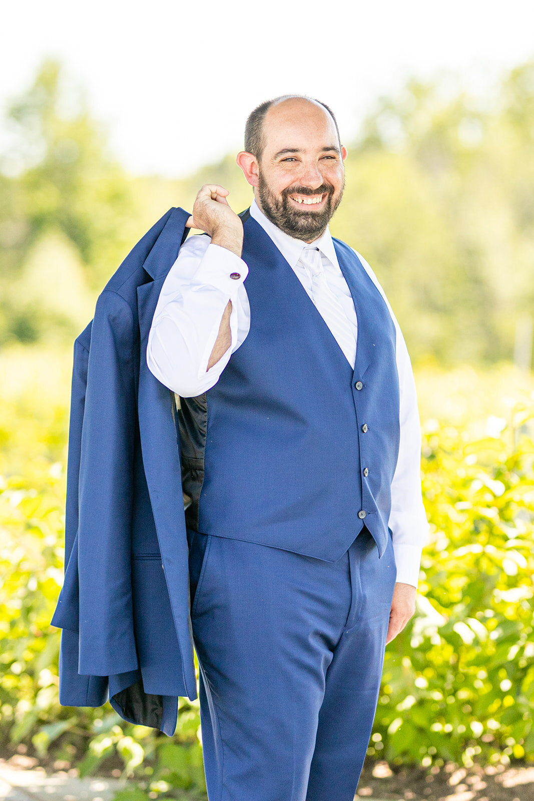 Groom holding jacket