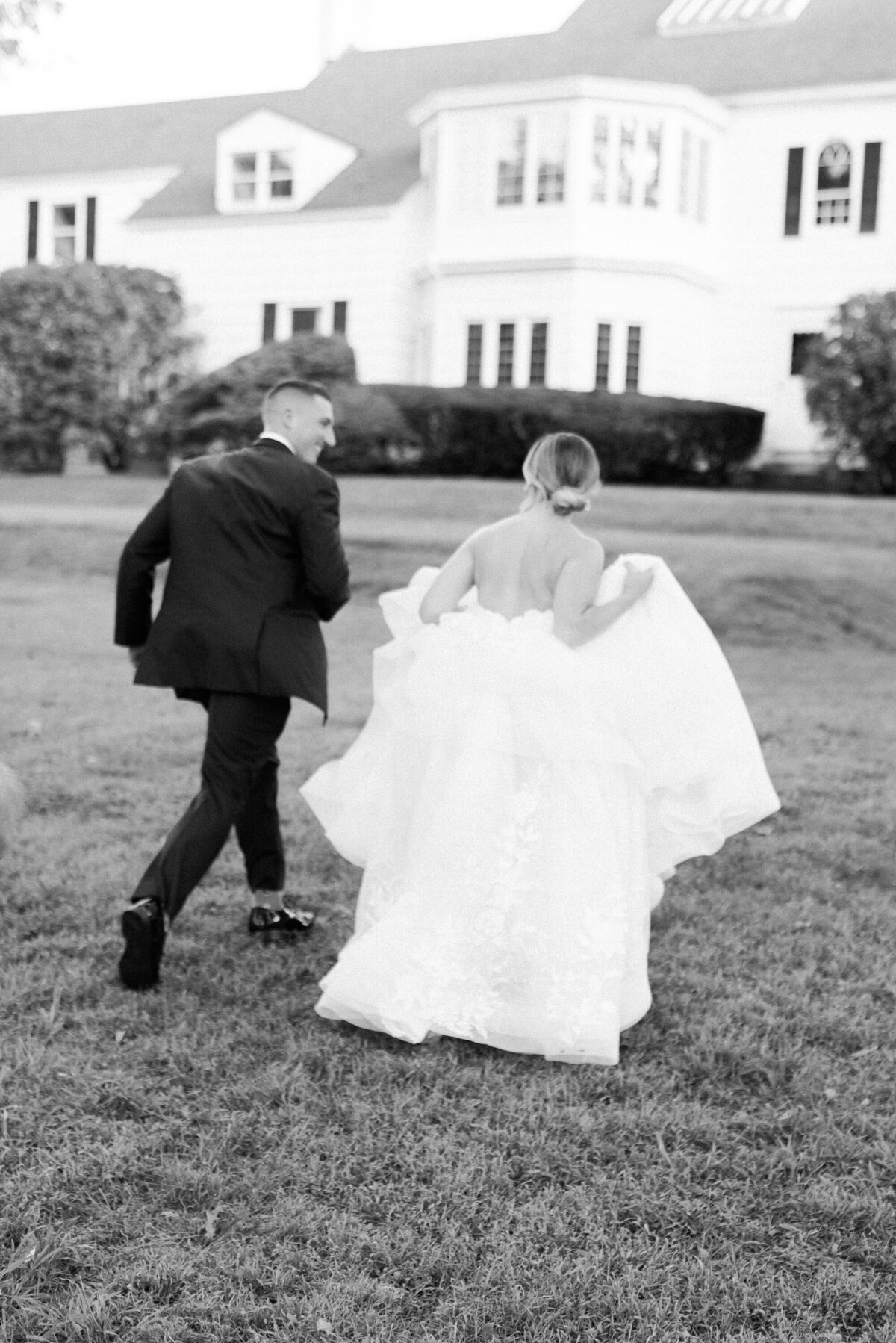 bride and groom running in grass
