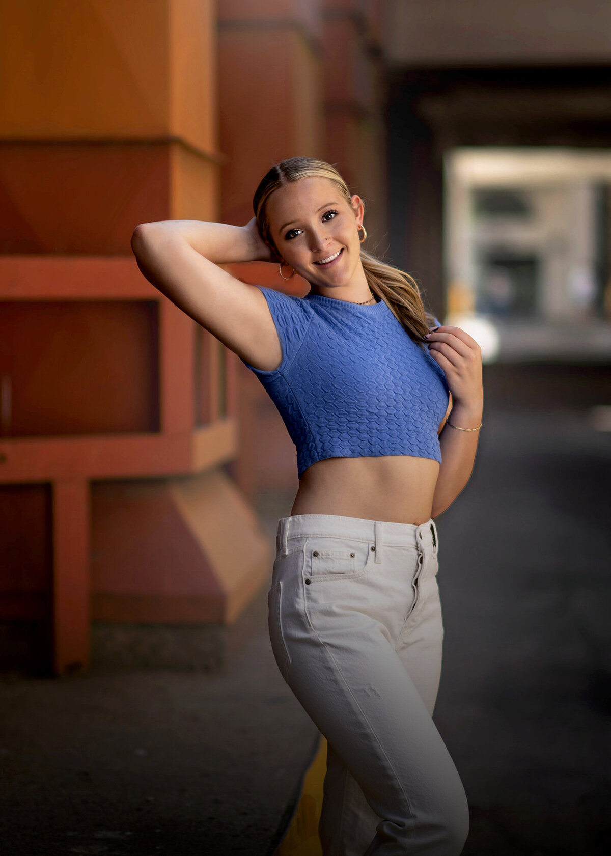 A high school senior walks through an outdoor hallway for her Pella Senior Photographer