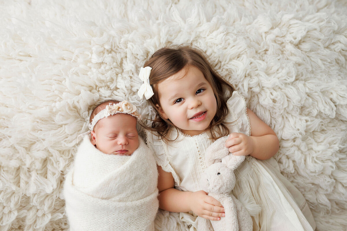 siblingandnewbornbigsisterholdsbunny