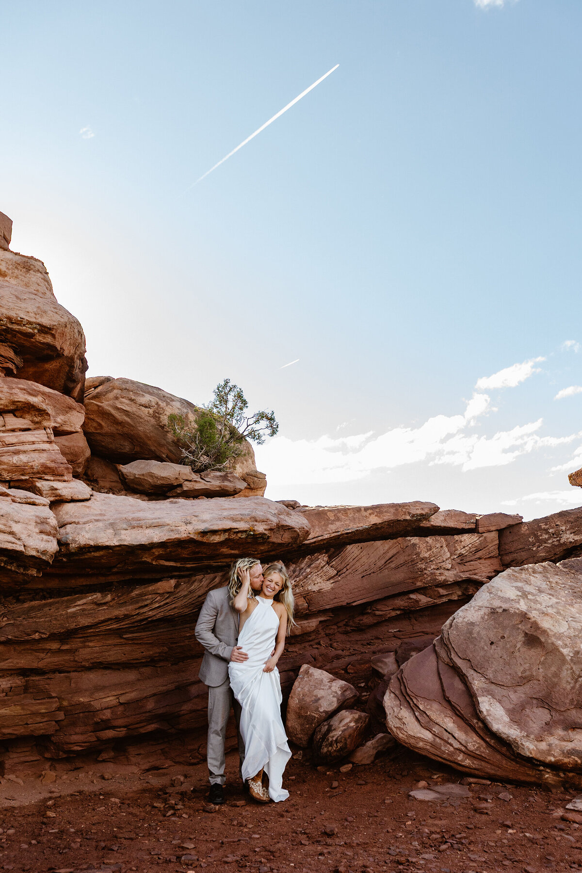A groom snuggles behind his bride during their Moab Elopement
