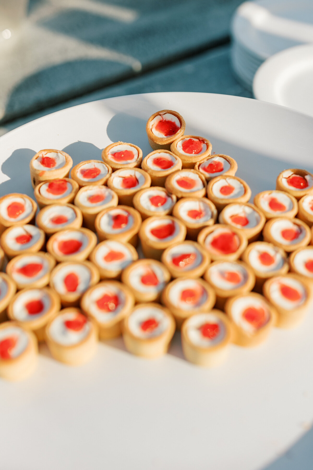 Mini tart appetizers with cherry topping on a platter at a Cancun wedding, styled and shot by a Philadelphia photographer.