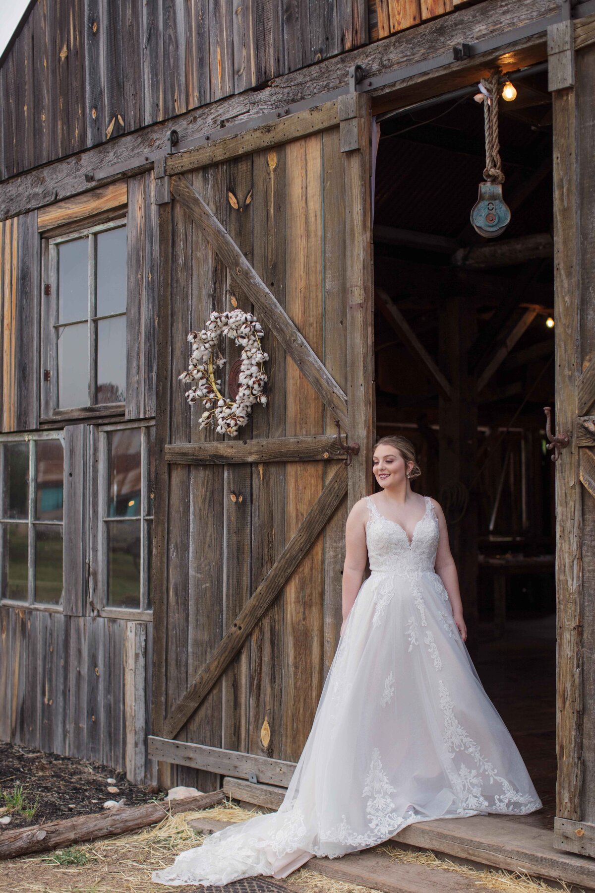 bride in gown standing by wood barn doors at The 1850 settlement in San Antonio Texas