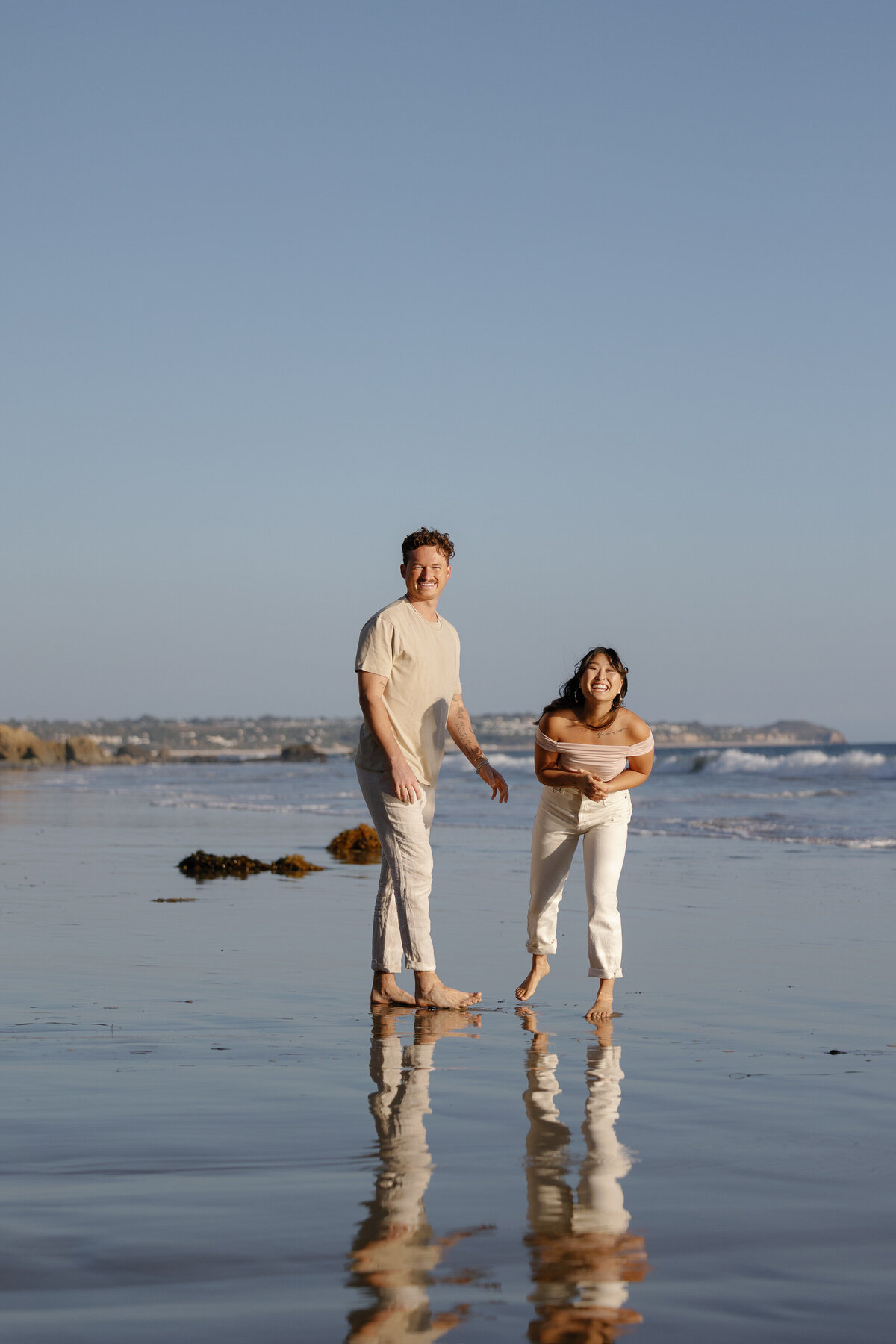 A couple laughing together at the water's edge