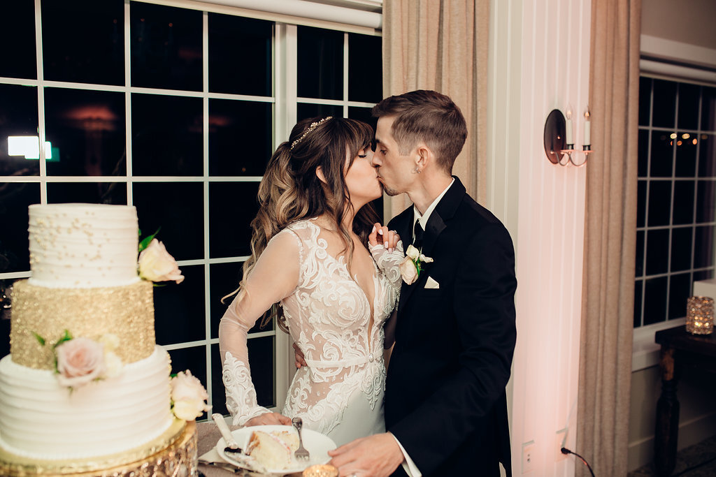 Wedding Photograph Of Bride And Groom Kissing Beside The Wedding Cake Los Angeles