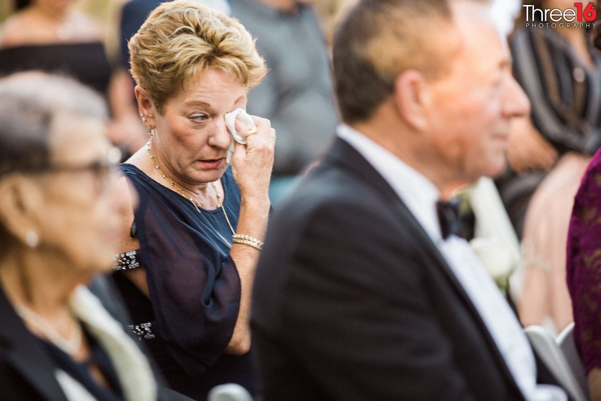 Audience member wipes a tear during wedding ceremony
