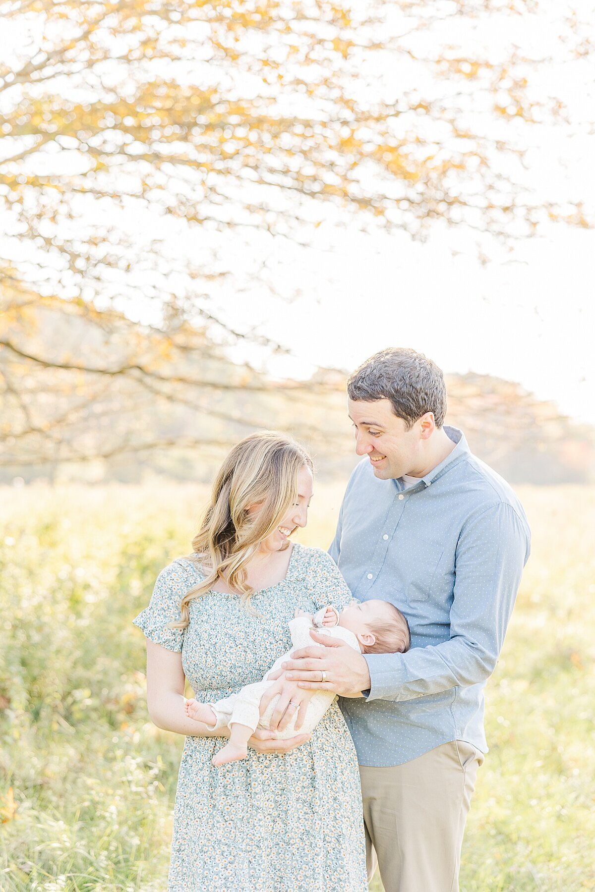 parents smile at baby during outdoor newborn photo session in Natick Massachusetts with Sara Sniderman Photography