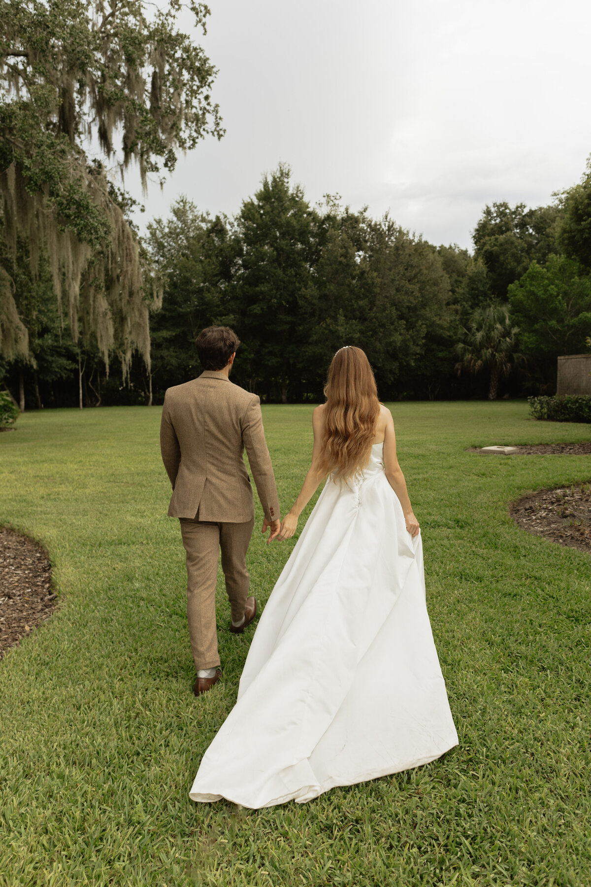 Romantic backyard wedding at The Palm Mansion in Umatilla, Florida with lush palm trees and floral arch