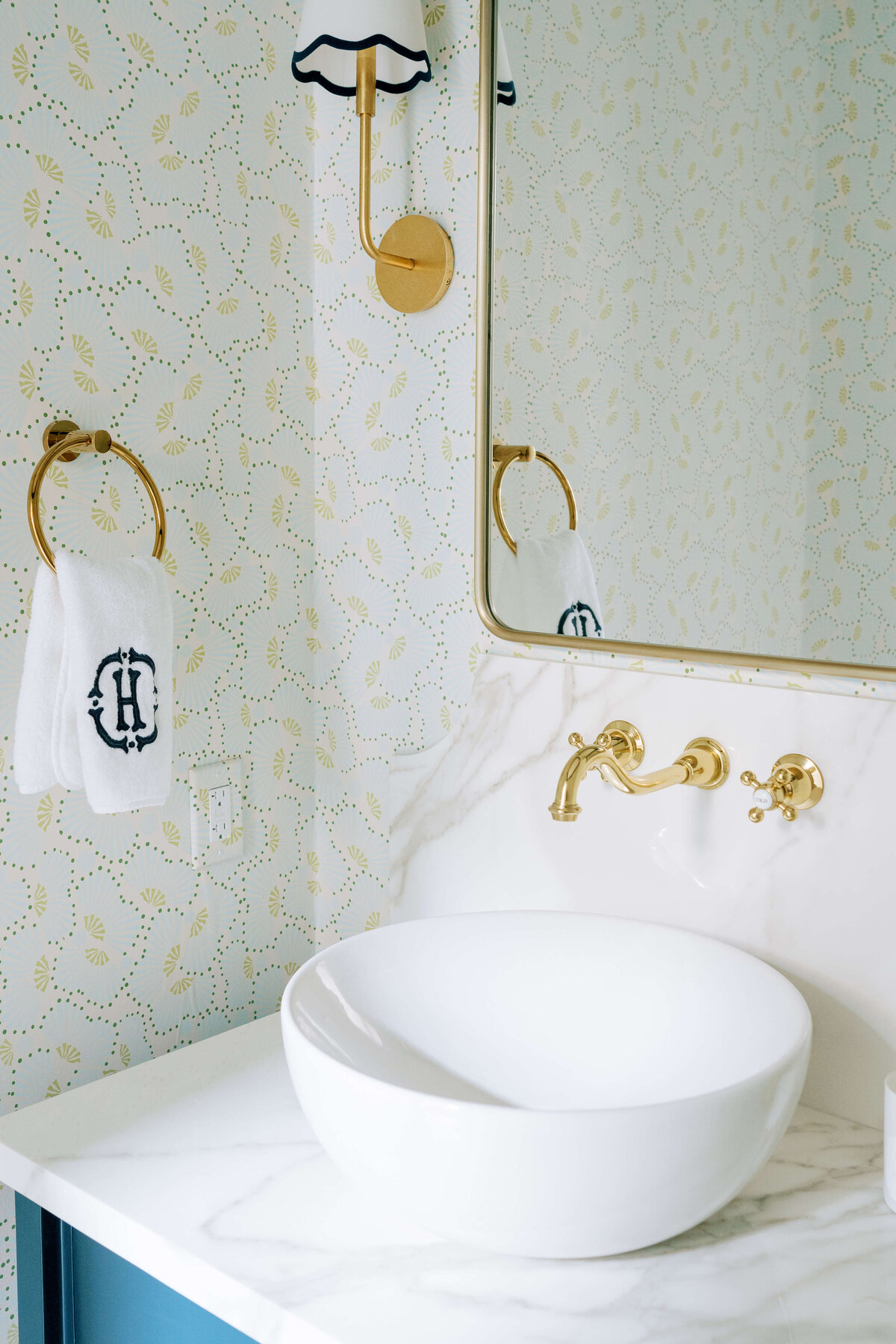 oyster creek studios hause white marble counters and gold fixture in bathroom
