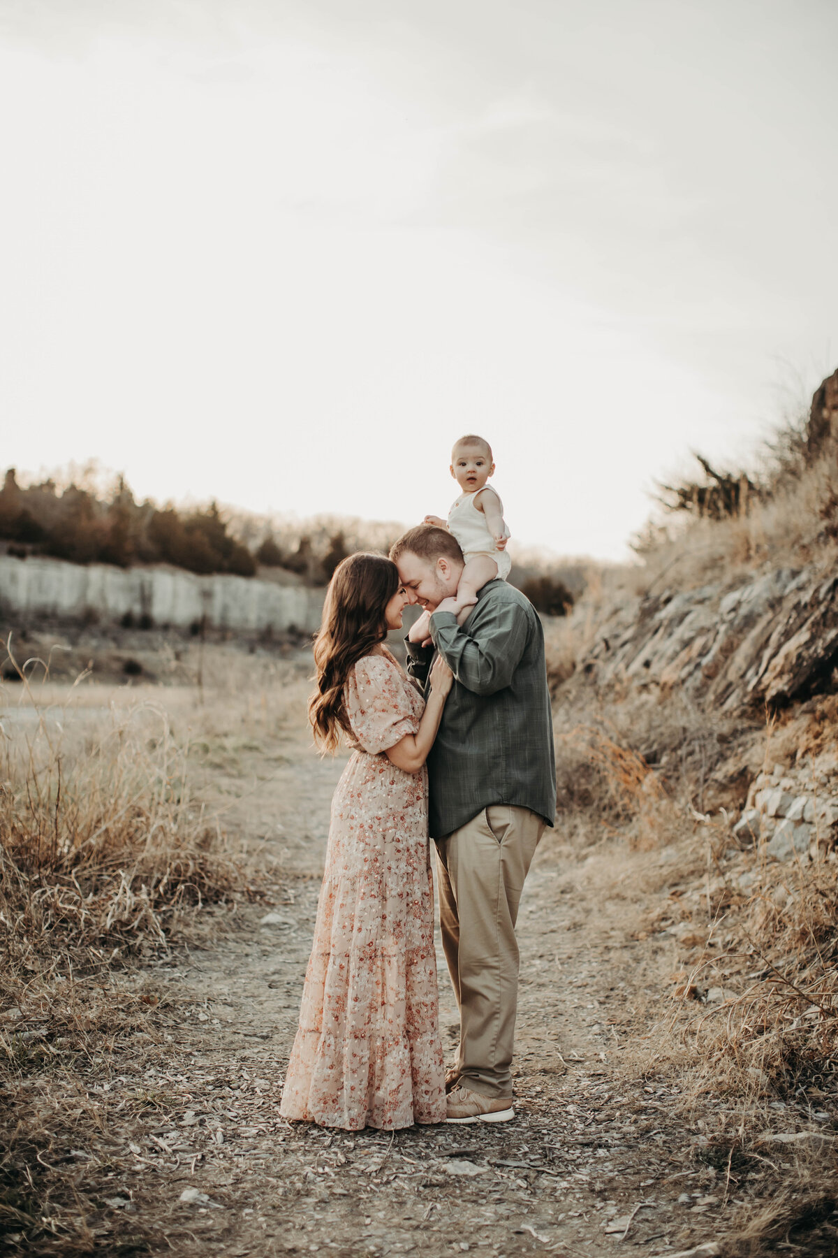 Mom and dad close with baby boy on dad's shoulders.