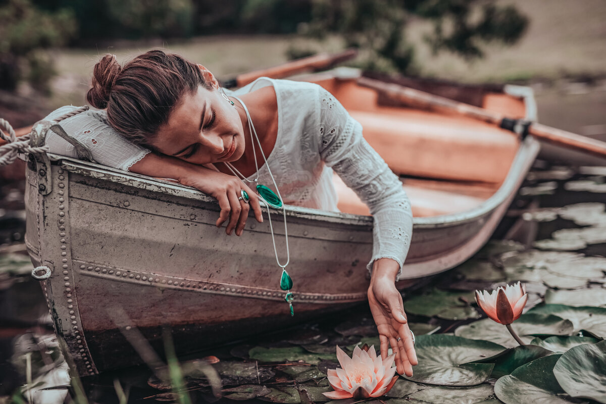 Elegant showcase of green emerald necklace on boat with female model