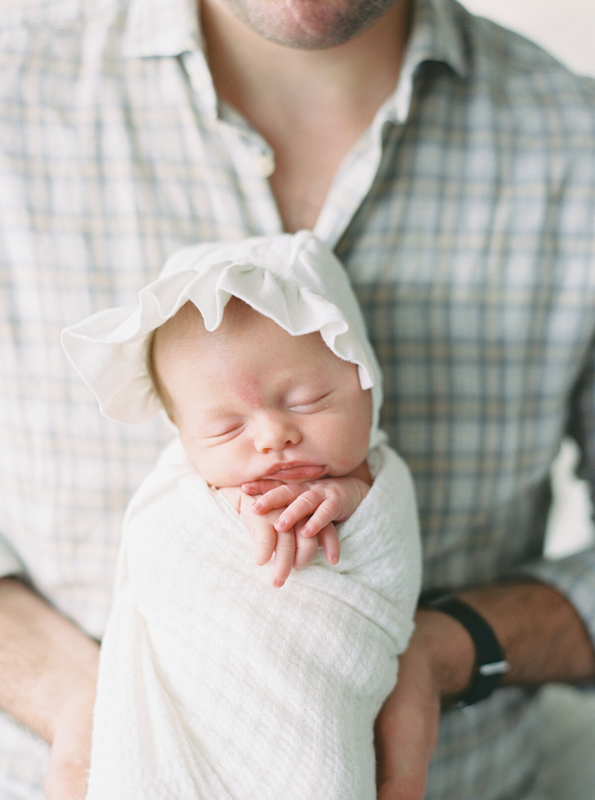 dad kissing newborn baby by photographer in madison wi talia laird photography