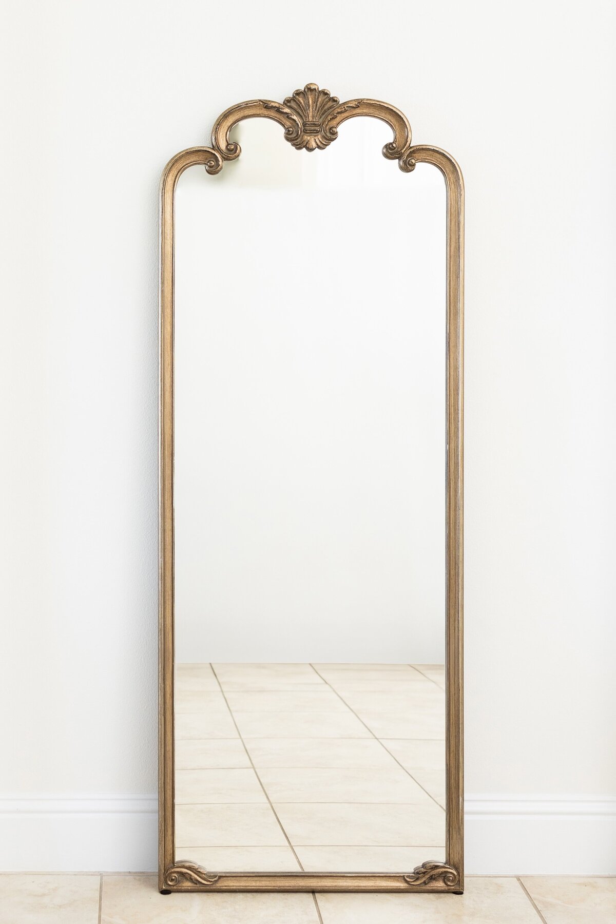 Large gold wood mirror with ornate arches at the top 