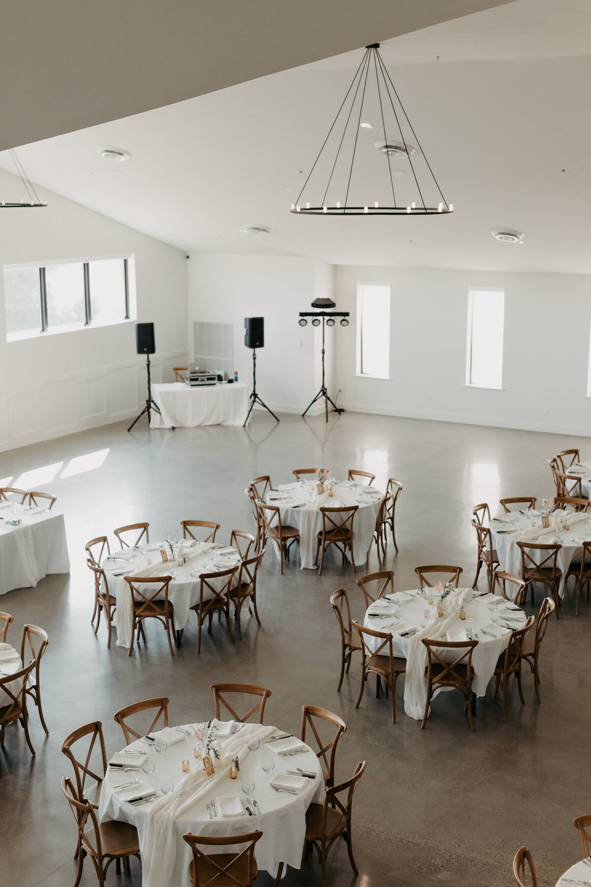 wide room shot of a modern clean wedding reception with lots of natural light and windows