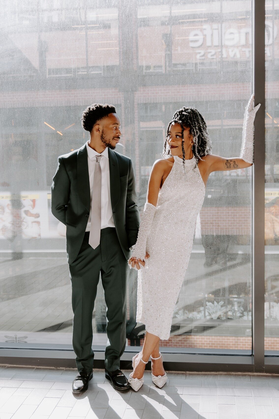 Bride and groom standing on a glass wall