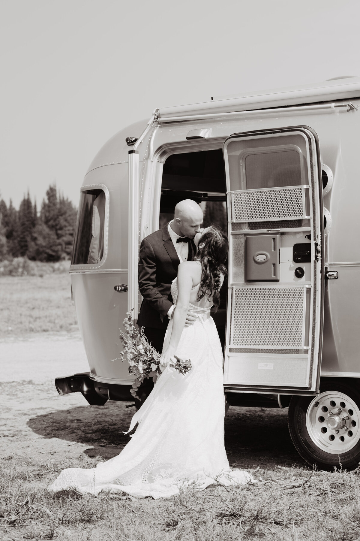 Jackson Hole photographers capture bride and groom kissing in airstream
