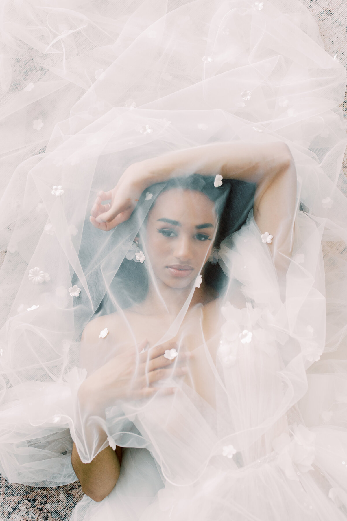 The bride with her veil cascading over her shoulders, embracing a bouquet of lush blooms, captured by Christine Grace Photography in Toronto.