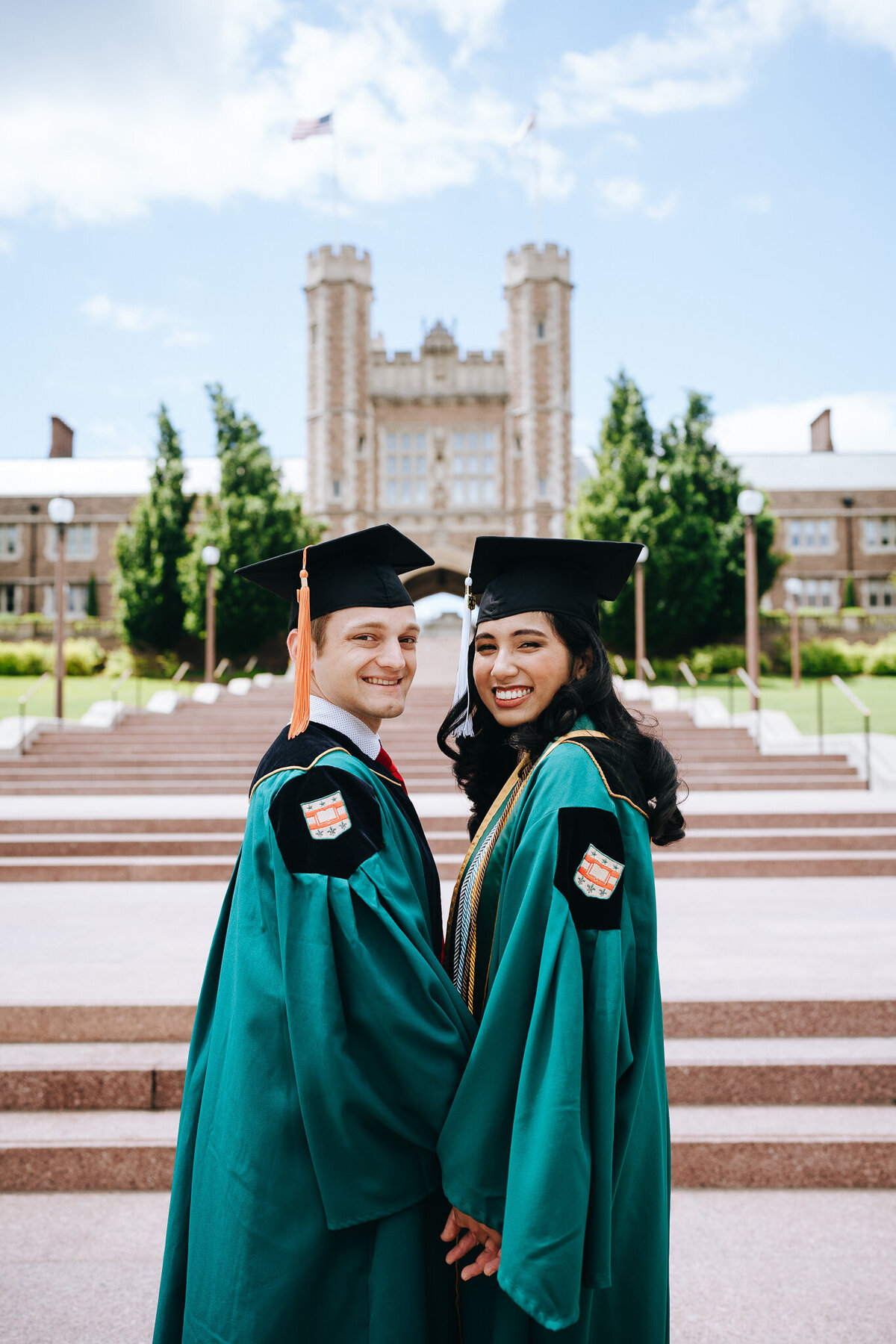 graduating couple holding hands in front of brookings hall