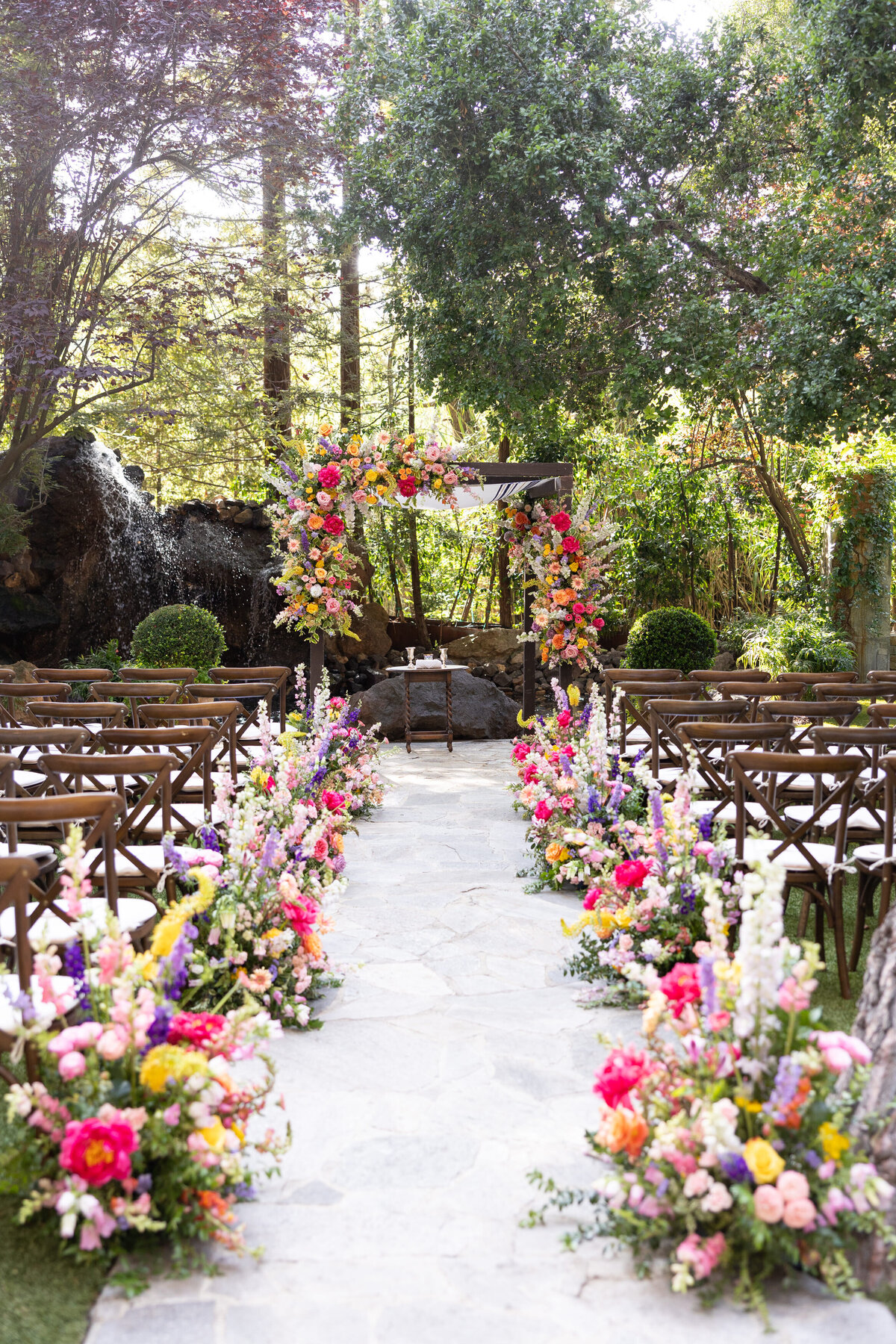 A wedding ceremony aisle lined with colorful flowers