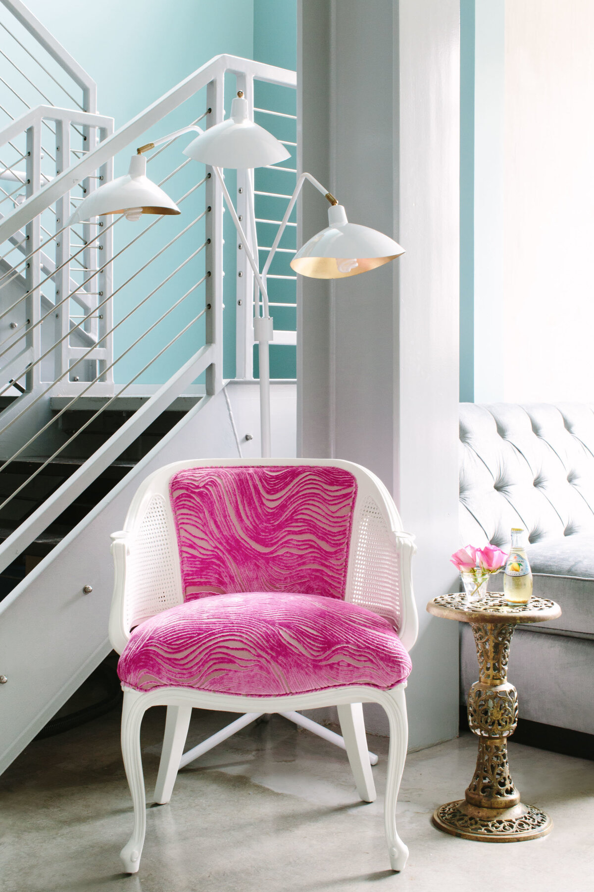 French chair with pink upholstery paired with a modern floor lamp