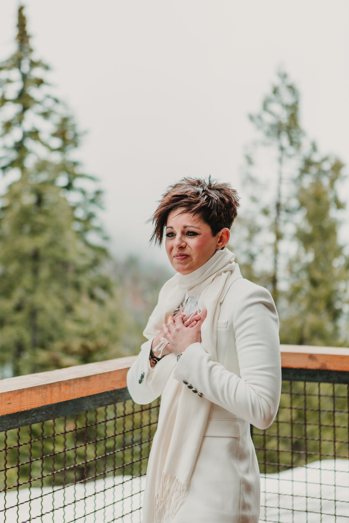 A Bride clutches her chest while crying on her wedding day in Yosemite, CA