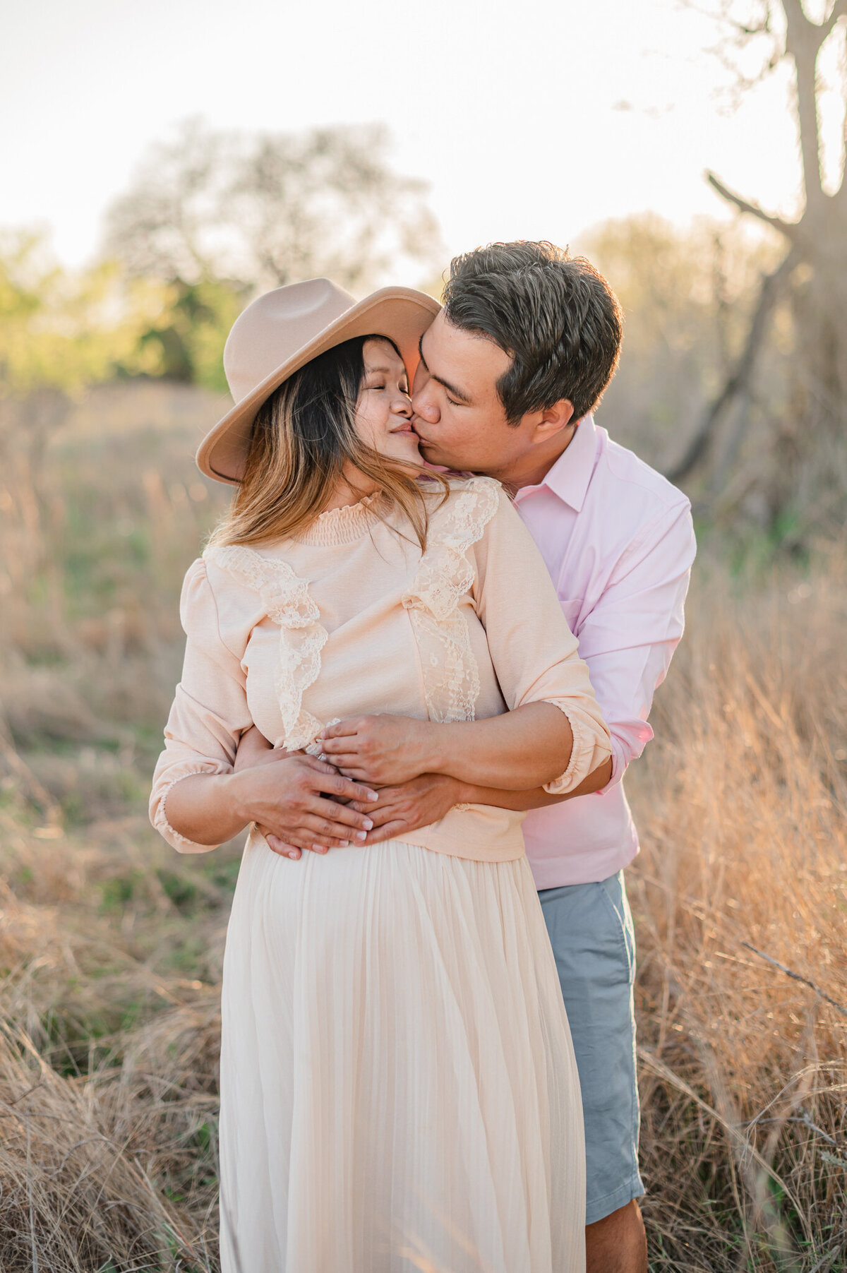 Expectant couple embraces during maternity pictures in San Antonio.