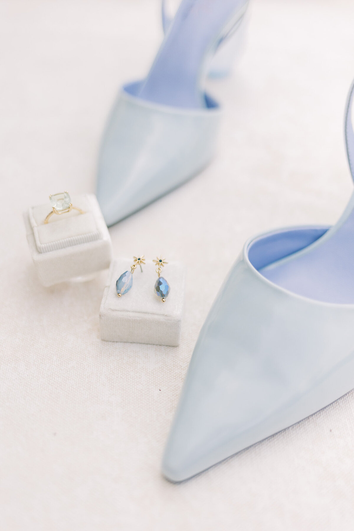 blue wedding shoes, blue ear rings next to an engagement ring