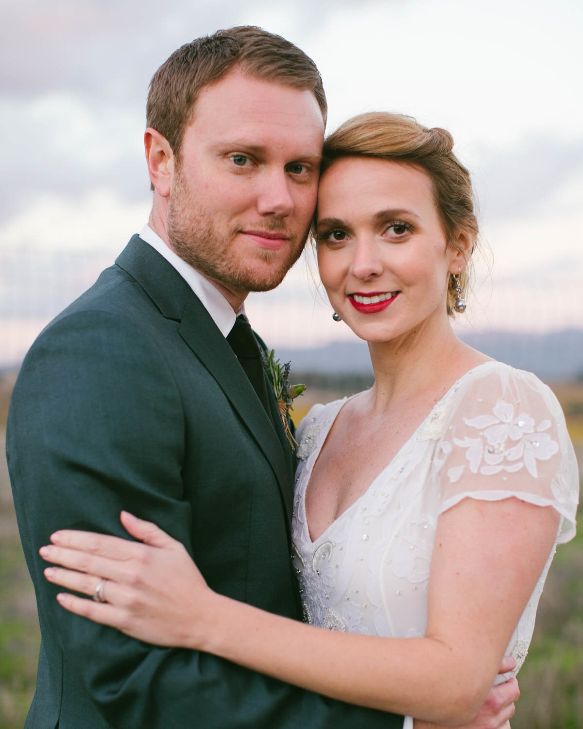 Intimate portrait of Bride and Groom holding each other smiling at the camera