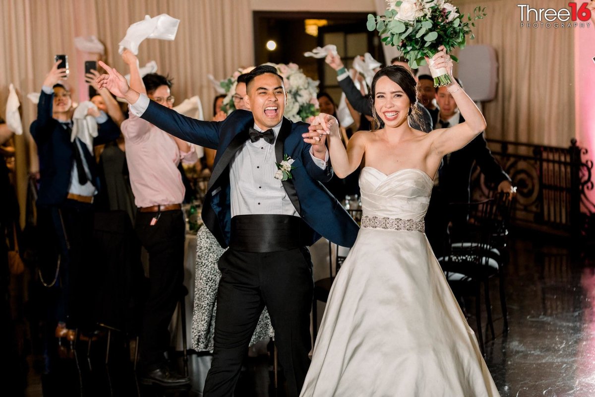 Bride and Groom enter the reception area as guests cheer