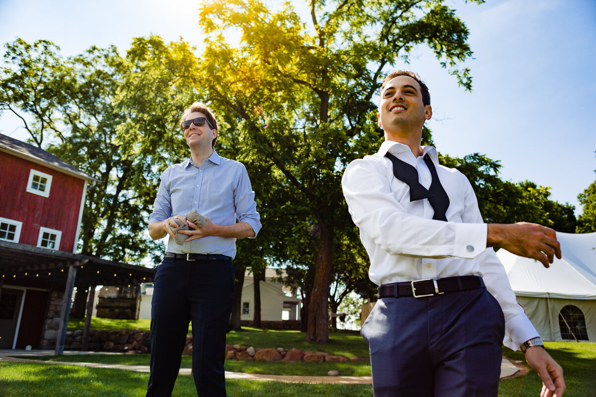 One of the top wedding photos of 2020. Taken by Adore Wedding Photography- Toledo, Ohio Wedding Photographers. This photo is of a groom playing cornhole before the wedding at Cornman Farms in Ann Arbor Michigan