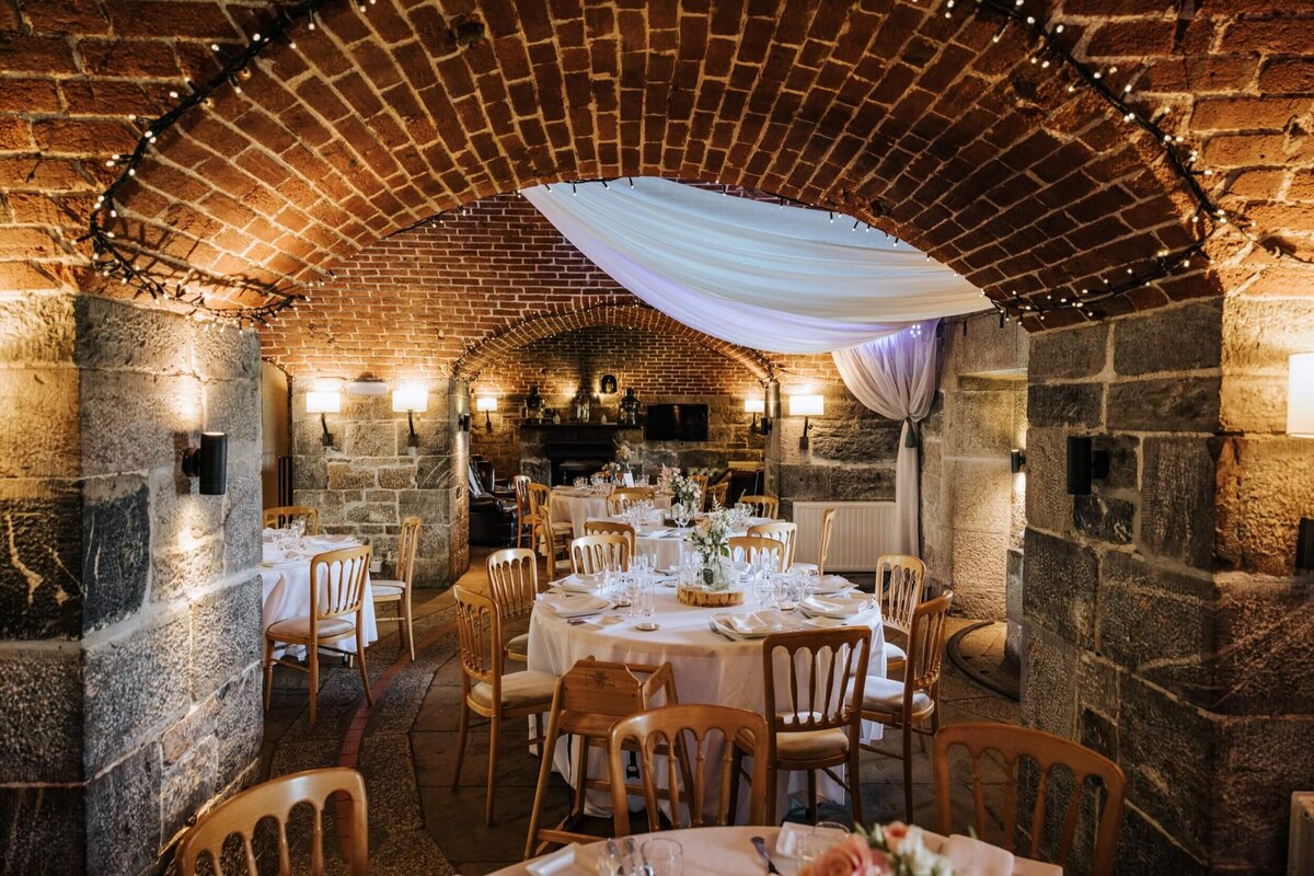 A dining room with tables and chairs and a brick ceiling