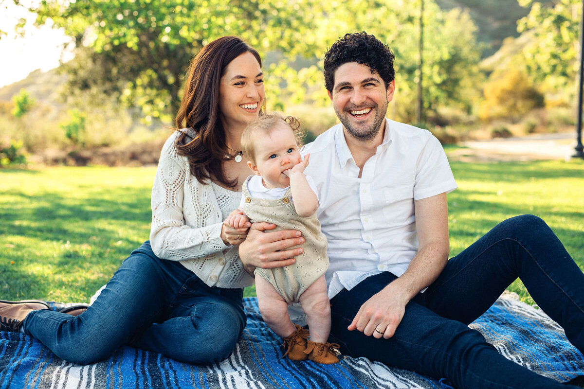 Family Portrait Photo Of Smiling While Holding Their Baby  In Los Angeles