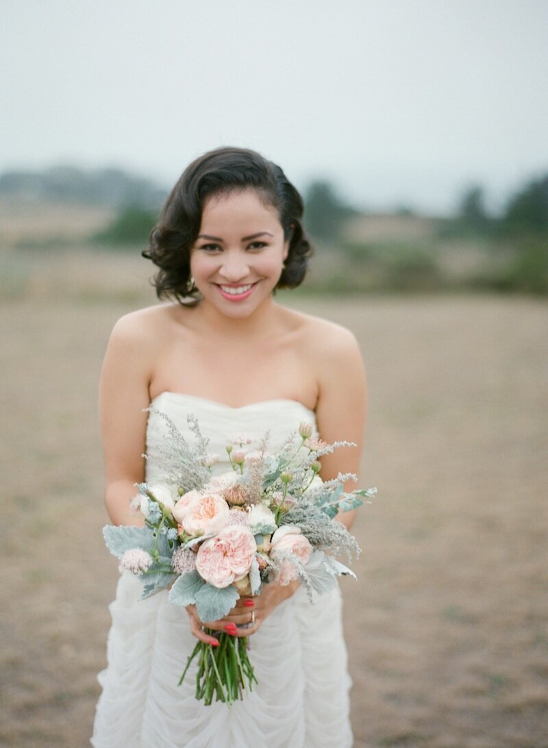 bride holding peach bouquet