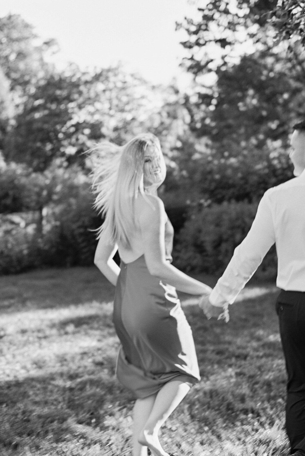 Black and white image of woman looking back while holding man's hand, Columbus session by Philadelphia photographer.