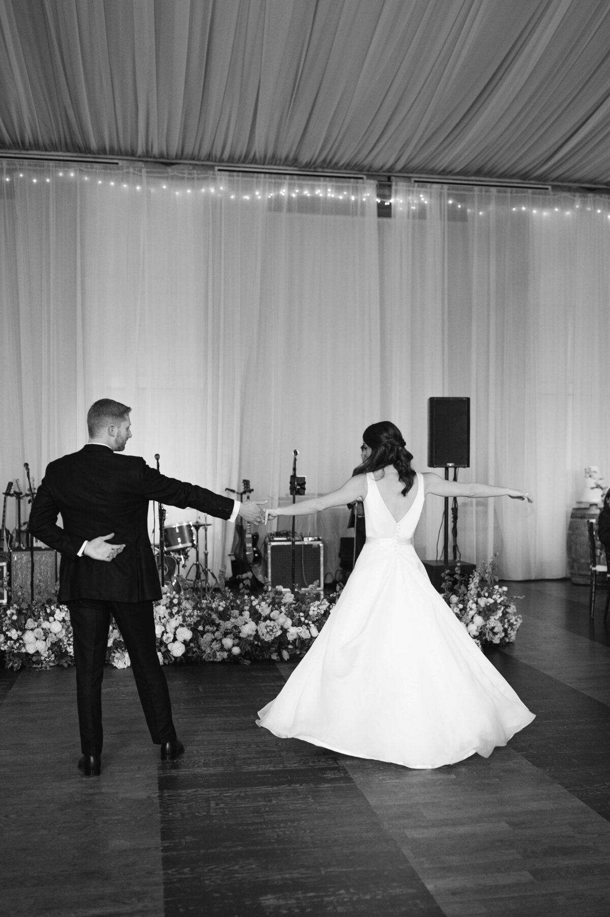 B&W image of couple dancing first dance during reception.