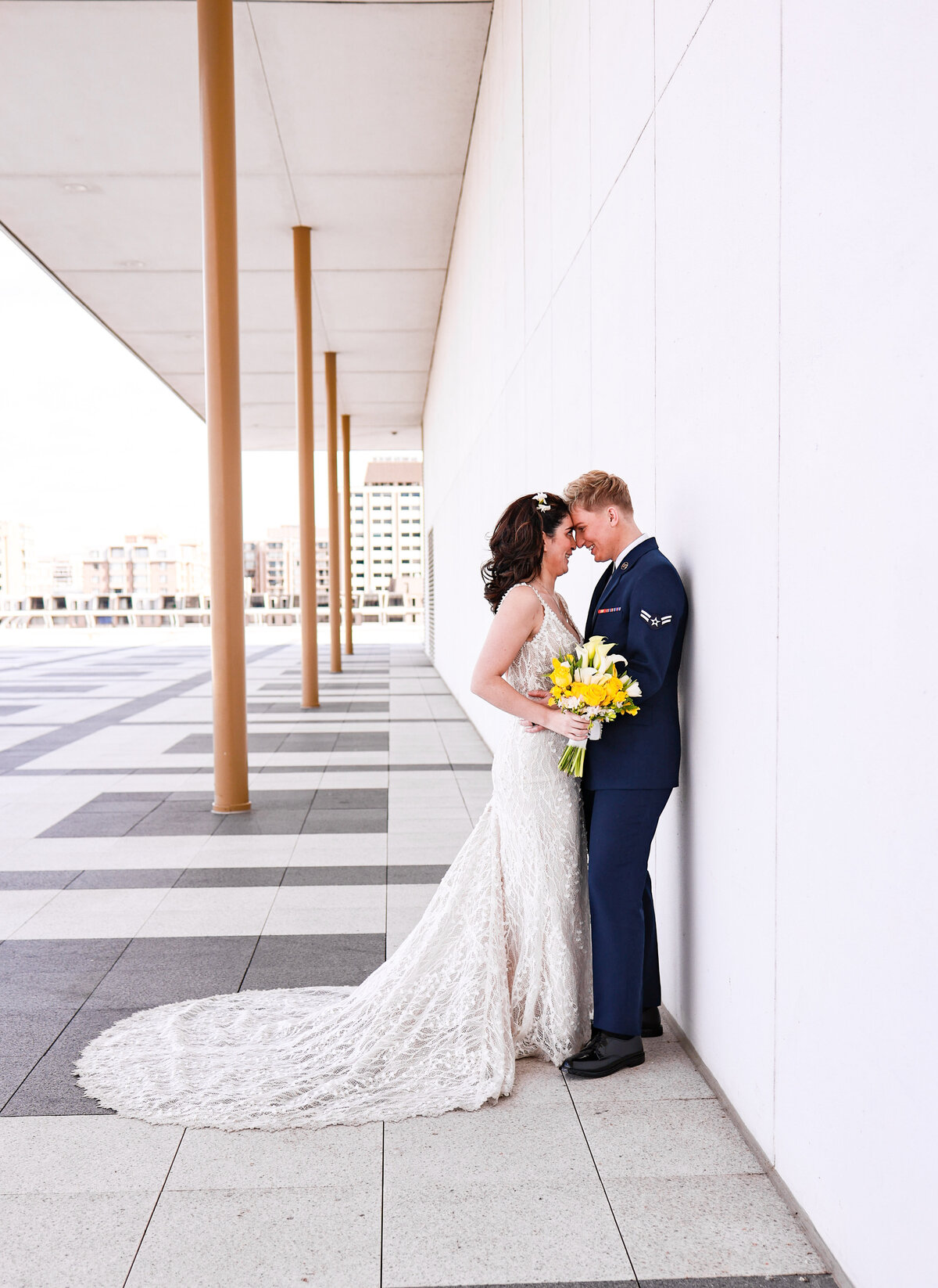 two brides smiling and hugging each other wearing Air Force uniform and lace wedding dress in Washington DC by Washington DC elopement photographer Amanda Richardson Photography