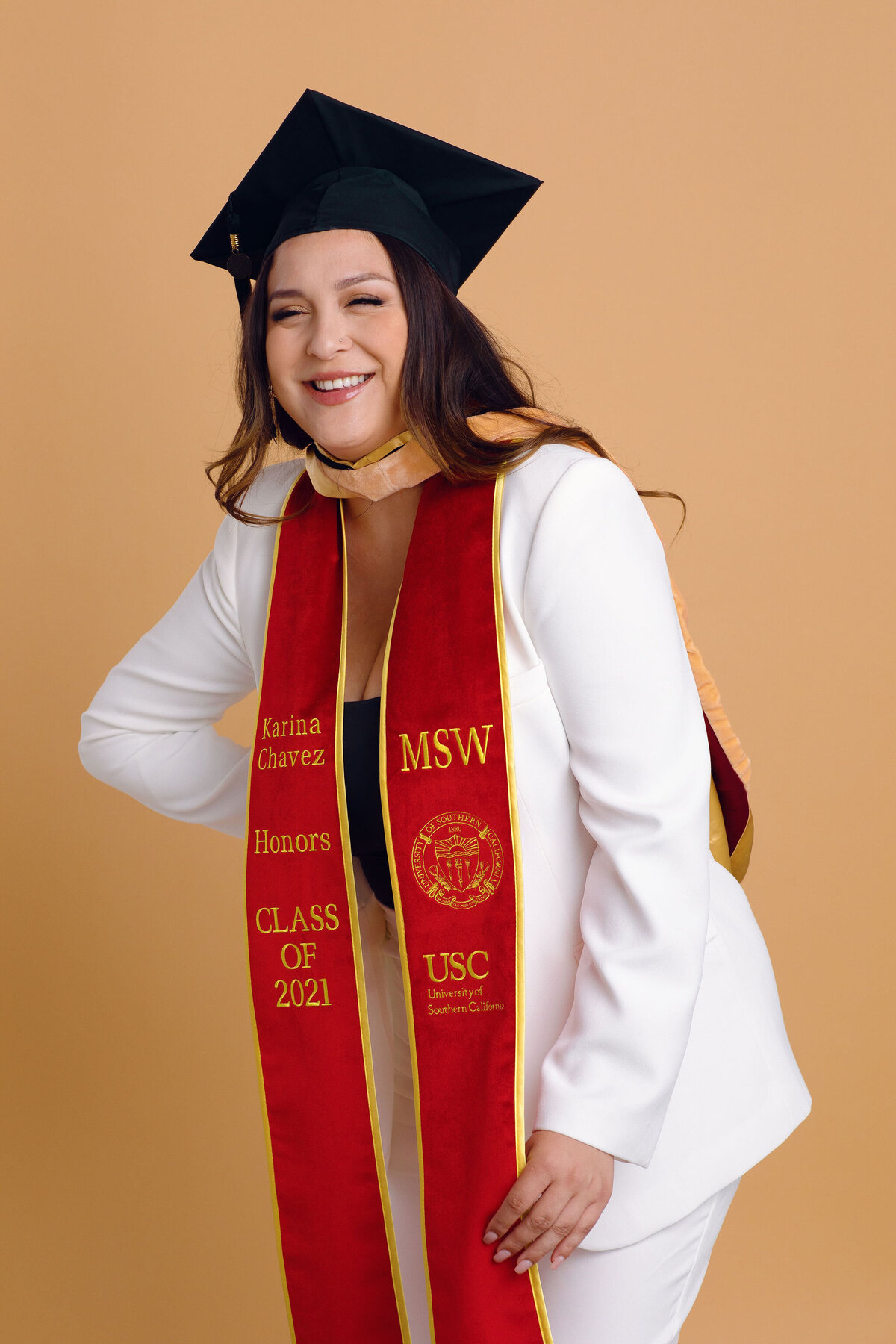 Graduation Portrait Of Young Woman Wearing White Suit And Black Graduation Cap Los Angeles
