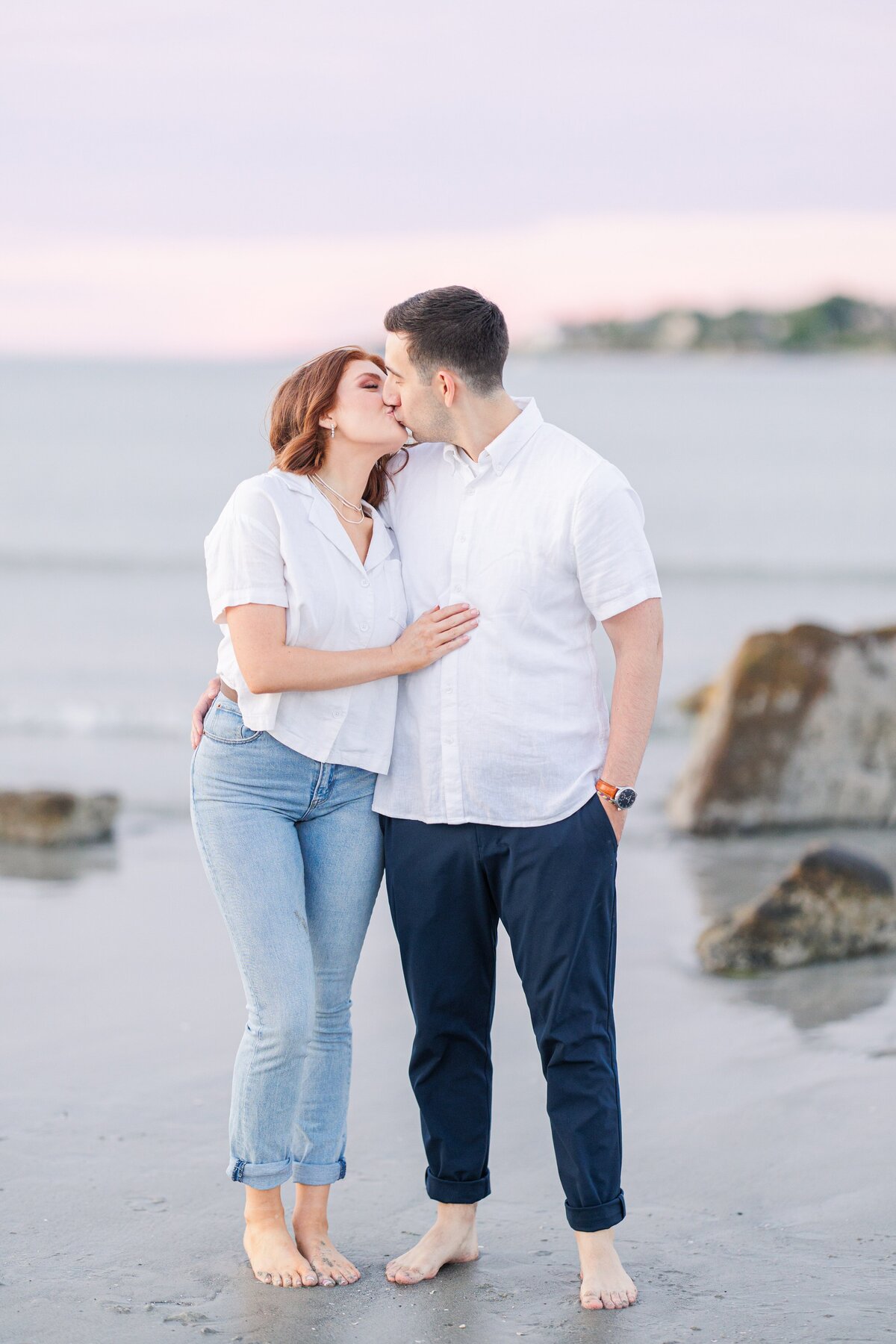 Close up of a couple kissing on Wingaersheek Beach during their sunset engagement session.