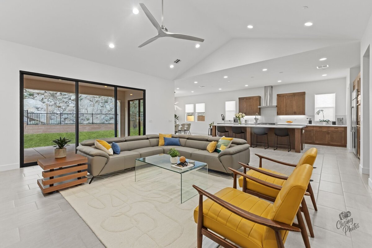 Bright and modern living room with a view into the kitchen. Modern furnishings and a view to the backyard.
