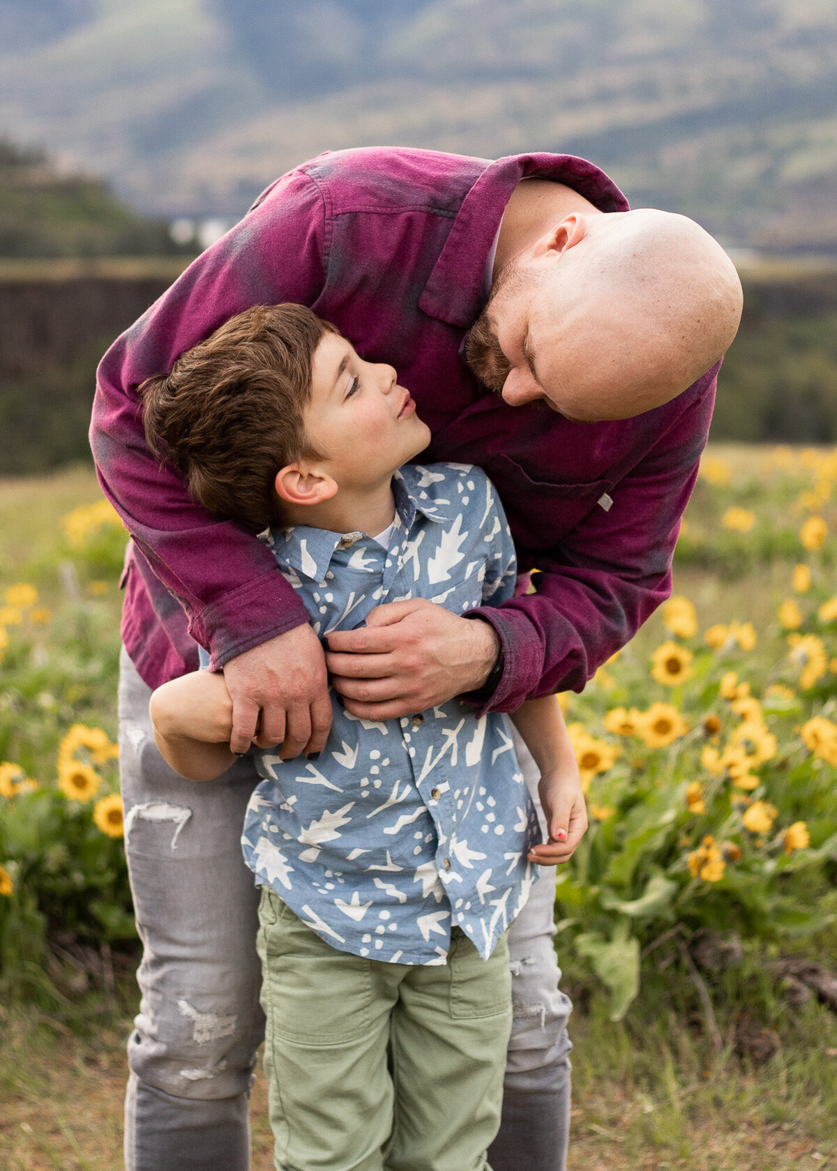 Father and son hugging in wildflower field.