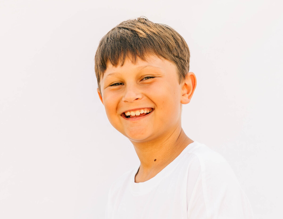 School portrait of preteen boy with natural pose, white backdrop