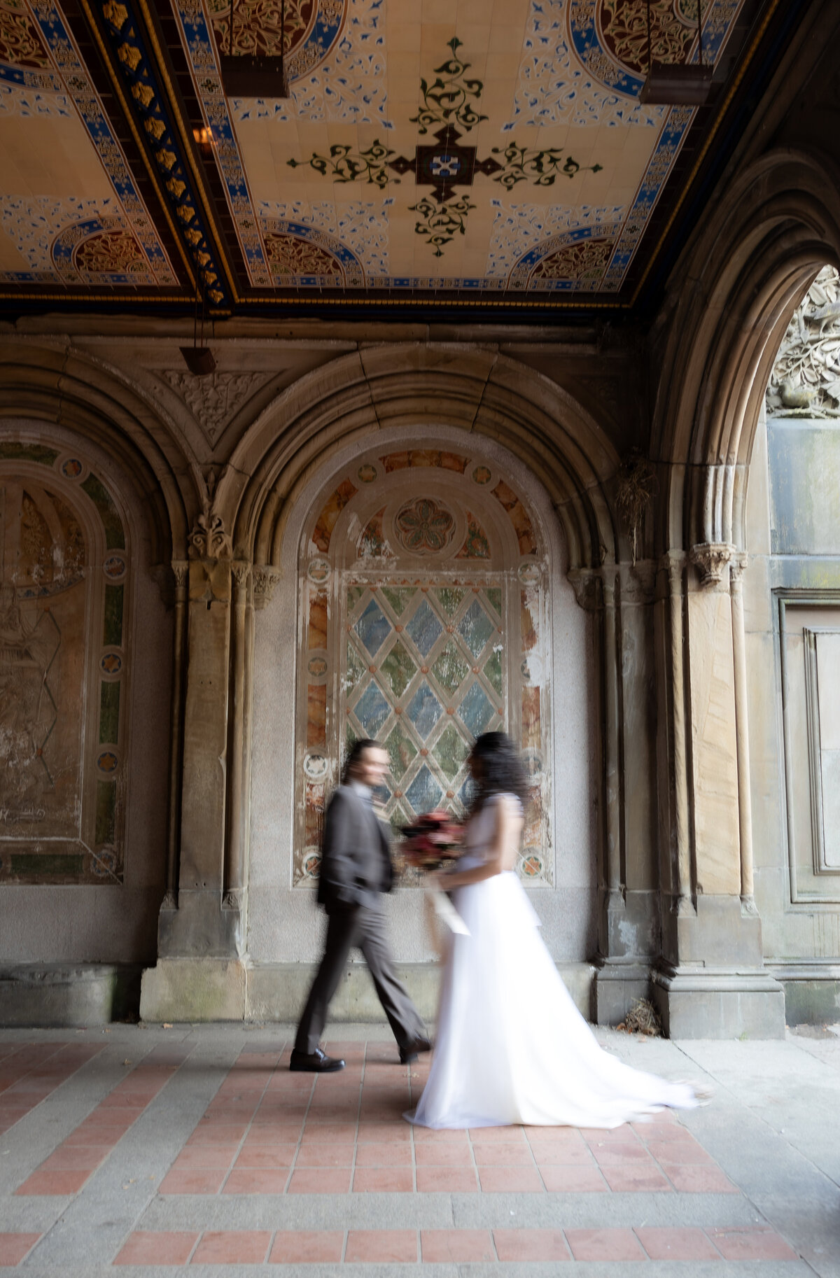 The couple sharing a tender moment beneath Central Park’s beautiful stone arches.